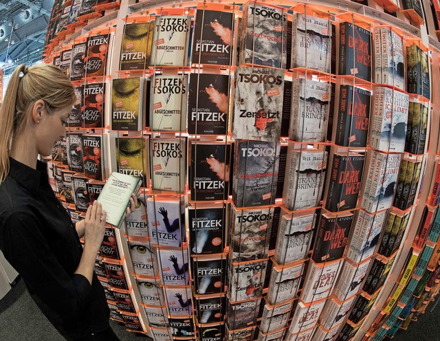 Eine Frau blttert auf der Frankfurter Buchmesse in einem Buch.  | Foto: dpa