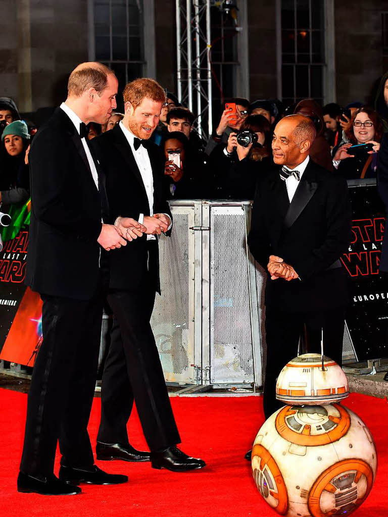 Die britischen Prinzen William (l) und Harry (M) nehmen den Droiden BB-8 unter die Lupe.