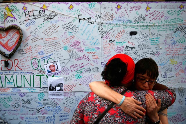 Zwei Frauen trauern am Tag nach dem Gr...enkwand um die Opfer der Katastrophe.   | Foto: afp