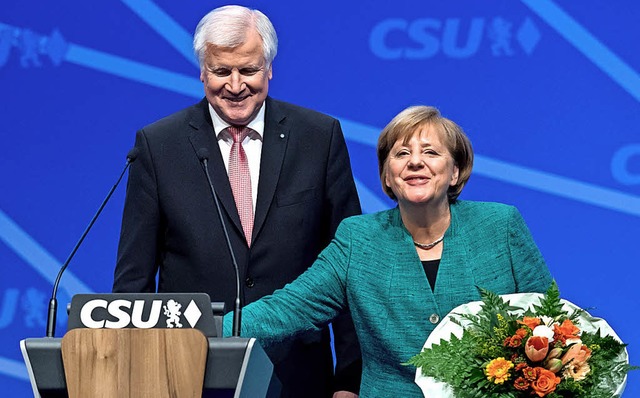 Blumen fr die Kanzlerin: Horst Seehofer und Angela Merkel  | Foto: dpa