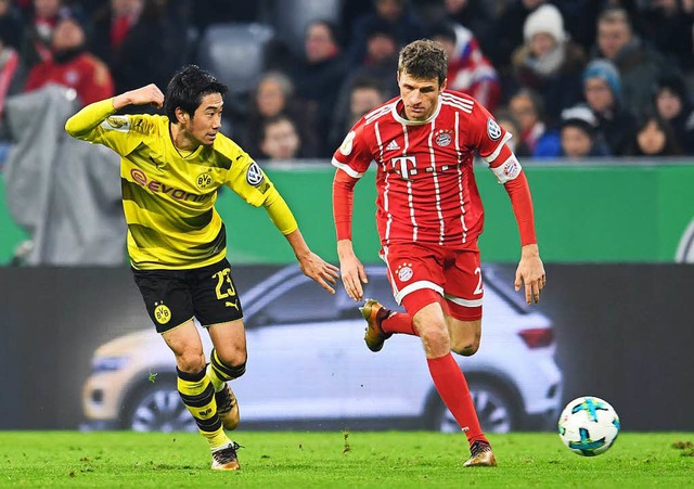 Dynamisch spielt Thomas Mller den Ball vorbei an Shinjii Kagawa  | Foto: dpa