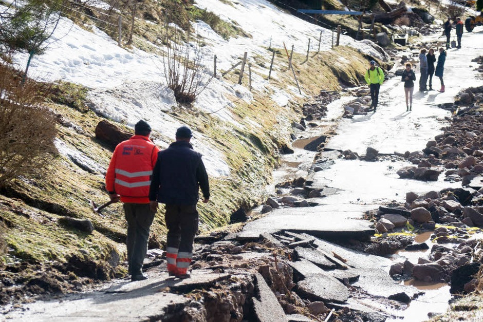 Zwei Männer auf einer unterspühlten Straße in Menzenschwand. (Foto: dpa) Zwei Männer auf einer unterspühlten Straße in Menzenschwand. (Foto: dpa)