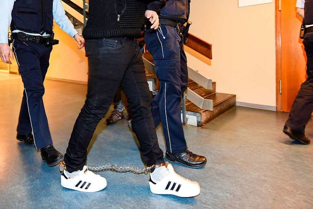 K. wird am Montag von Justizbeamten in den Gerichtssaal gebracht.  | Foto: dpa