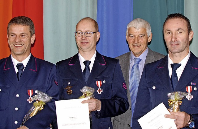 Das silberne Feuerwehr-Ehrenzeichen f...ter Josef Schweizer gratulierte ihnen.  | Foto: Louis Gross