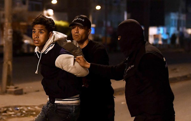 Sicherheitskrfte nehmen einen Demonst...enbezirken der Hauptstadt Tunis fest.  | Foto: AFP