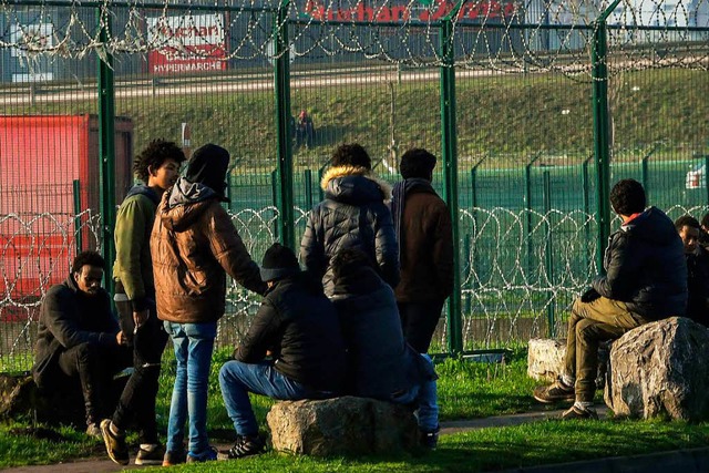 Die Migranten am Zaun hoffen darauf, e...aschen, um nach England zu gelangen.    | Foto: AFP