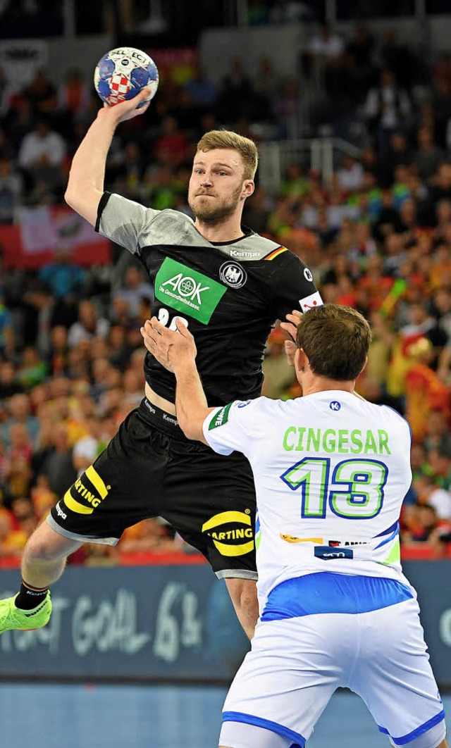 Philipp Weber (l) wirft den Ball ber Sloweniens Darko Cingesar.   | Foto: DPA