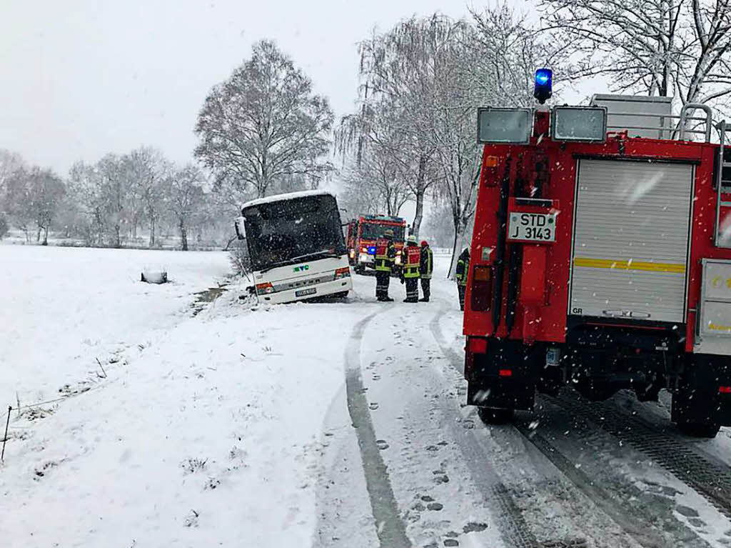 Rettungskrfte bergen  in Aschhornermoor (Niedersachsen) einen bei glatter Fahrbahn in den Seitenstreifen gerutschten Schulbus. Bei dem Unfall wurde niemand verletzt.