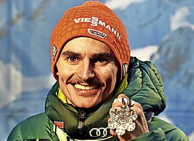 Richard Freitag zeigt seine Bronzemedaille.   | Foto: AFP