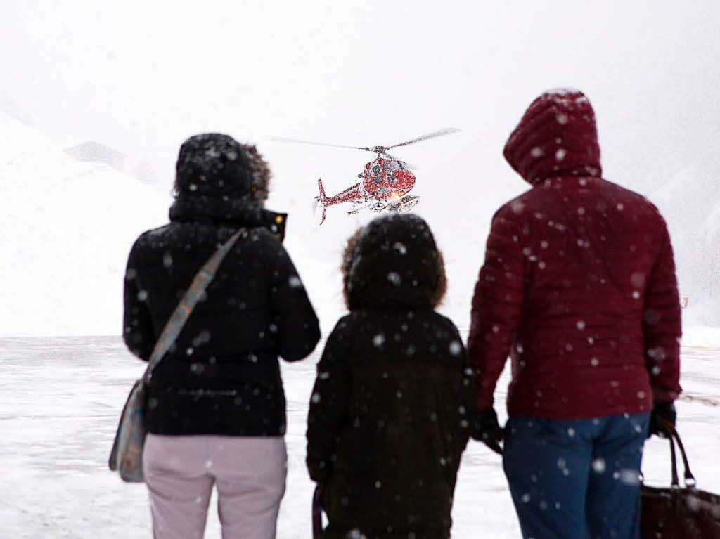 Eine Familie wartet mit ihrem Gepck in Zermatt um per Helikopter nach Tsch  zu fliegen. Der Wintersportort Zermatt in der Schweiz ist nach ergiebigen Schneefllen erneut nur noch aus der Luft erreichbar.