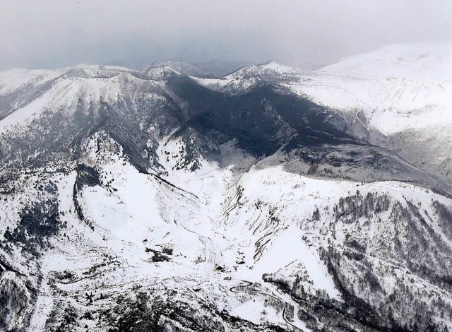 Asche des Vulkans Mount Kusatsu-Shiran...eebedeckten Hngen eines Ski-Ressorts.  | Foto: dpa