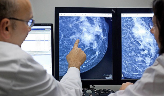 Ein Arzt weist an einem Computermonito...igkeit in einer weiblichen Brust hin.   | Foto: dpa