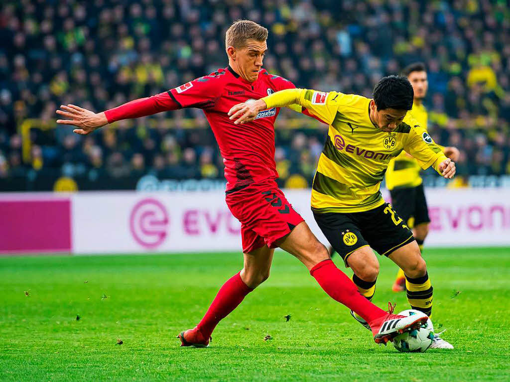 Nils Petersen versucht den Ball von Kagawa wegzuspitzeln.