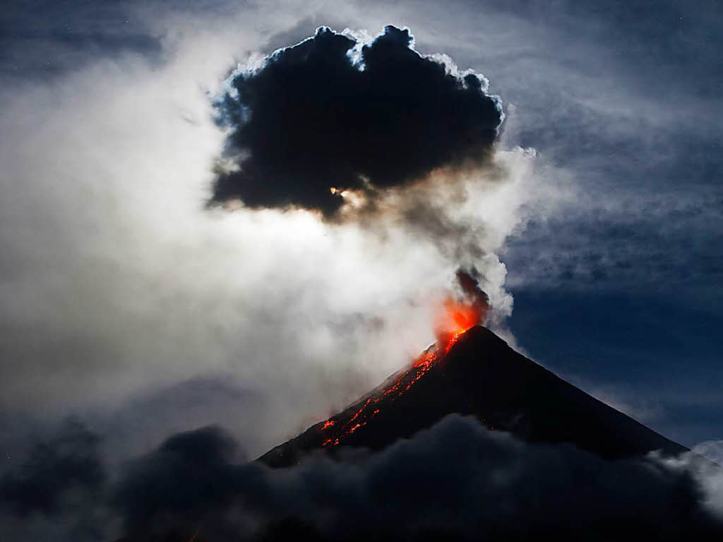 Philippinen, Santo Domingo: Der Vollmond, ein sogenannter Supermond, weil er sich besonders nah an der Erde befindet, steht ber dem Vulkan Mayon, whrend der Berg Lava spuckt.
