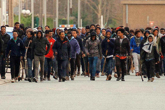 Junge  Migranten marschieren durch die Straen von  Calais.  | Foto: dpa
