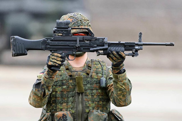 Ein Soldat hlt auf einem Truppenbung...Firma Heckler &amp; Koch in der Hand.   | Foto: dpa