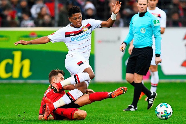 SC-Spieler Amir Abrashi (am Boden) grtscht gegen den Leverkusener Leon Bailey.  | Foto: dpa