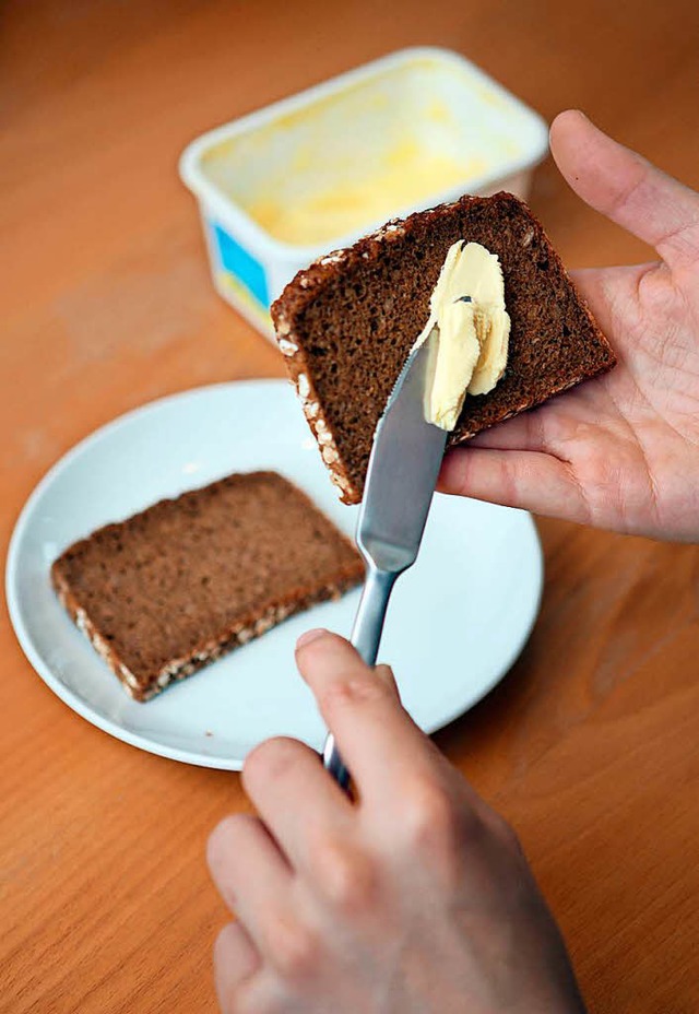 Mit der linken Hand ein Brot mit Butte...igionsbehrde ist das nicht erwnscht.  | Foto: Patrick Lux (dpa)