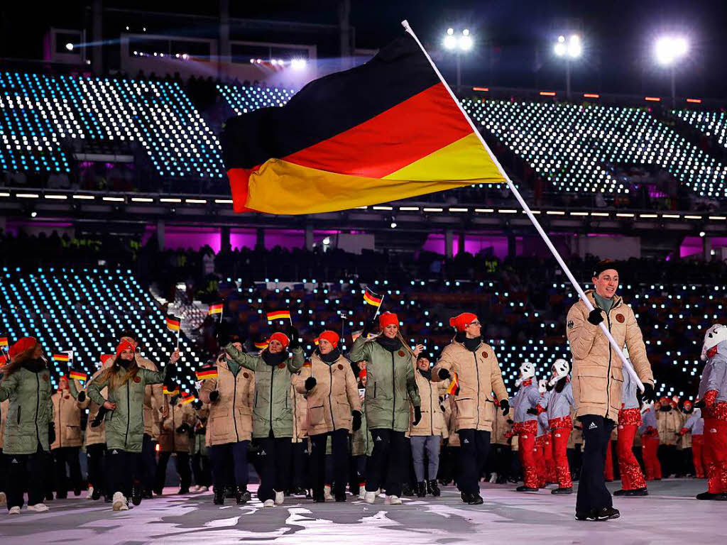 Das Deutsche Team mit Fahnentrger Eric Frenzel luft bei der Erffnungsfeier in das Olympiastadion.