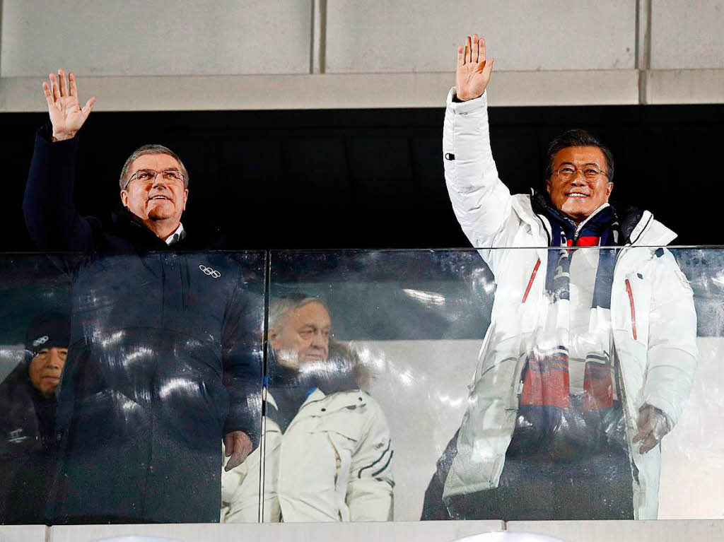 Der deutsche IOC Prsident Thomas Bach (l) und Moon Jae-in (r), Prsident von Sdkorea, winken bei der Erffnungsfeier im Olympiastadion.