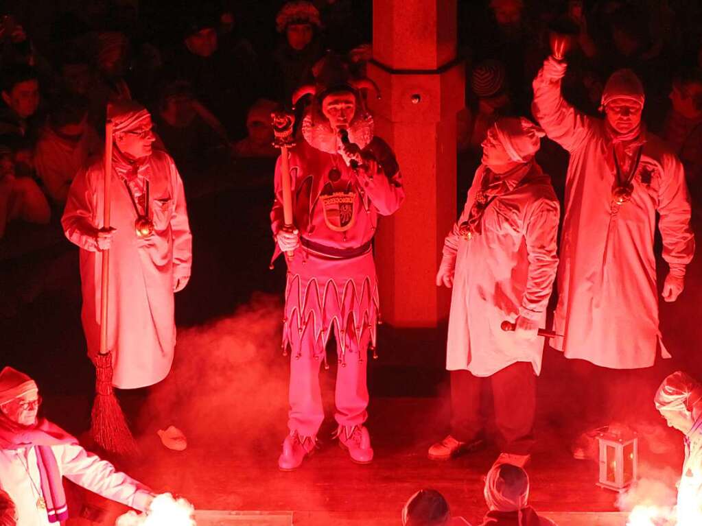 Hemdglunkerumzug in Endingen: Bejubelt von Tausenden wei gewandeter Narren tanzt d'r Jokili auf dem Rathausbrunnen mit Besenmann Michael Grtner, Erznarr Franz-Josef Vollherbst und Oberzunftmeister Ralph Baumann.