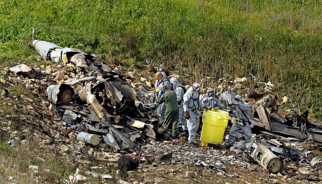 Israelische Experten untersuchen die berreste des Kampfflugzeugs.  | Foto:  AFP