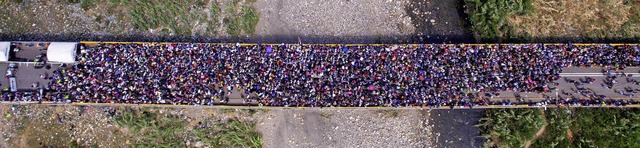 Zahlreiche Menschen stehen auf der Br...nze zwischen Venezuela und Kolumbien.   | Foto:  dpa