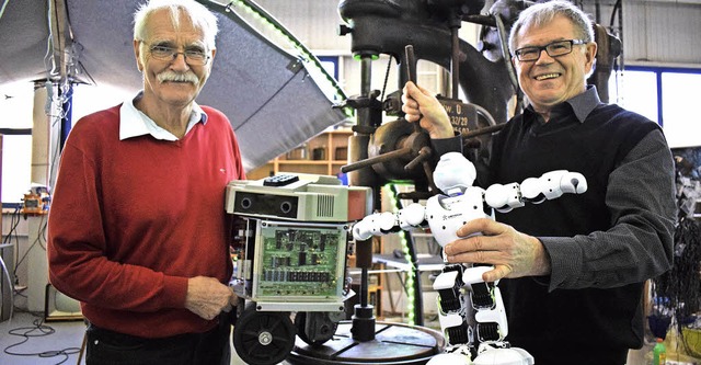 Vereinsvorsitzender Frank Leonhardt (r...r Schemitz mit einem lteren Roboter.   | Foto: J. Trauden