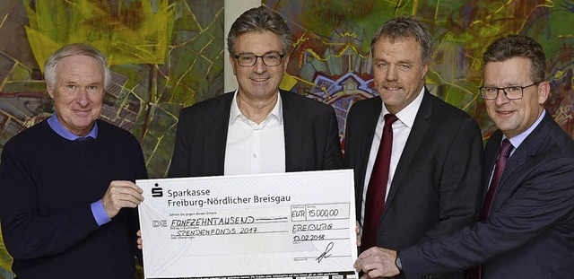 Axel Glatz von  Pfizer Freiburg  berr...einen  Spendenscheck ber 15 000 Euro.  | Foto: Ingo Schneider