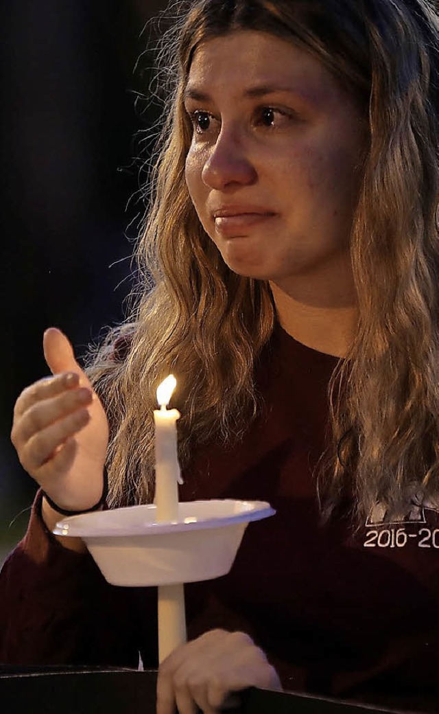 Gedenken an die 17 Toten von Parkland: Eine Schlerin mit einer Kerze.  | Foto:  Afp