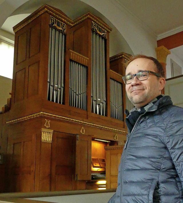 Pfarrer Christian Mack vor der Merklin...rbe  des deutschen Orgelbaus verweist.  | Foto: SENF