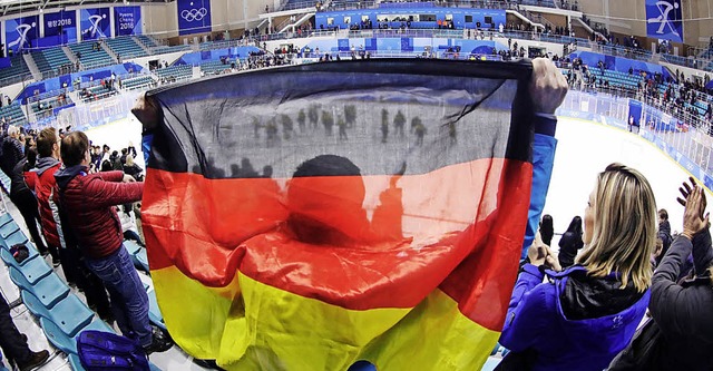 Ein deutscher Eishockey-Fan mit und ei... Knnen sie auch gegen Kanada jubeln?   | Foto: dpa