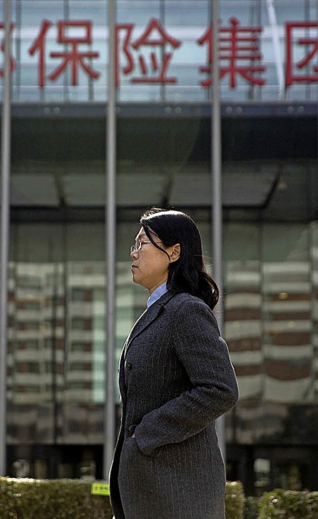 Frau vor Bros des chinesischen Versicherers  Anbang   | Foto: dpa