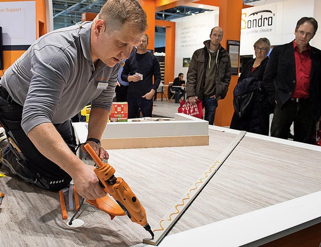 Ein Handwerker demonstriert bei der Me...uartiges Klebe- und Verlegeverfahren.   | Foto: Rainer Jensen/Deutsche Messe