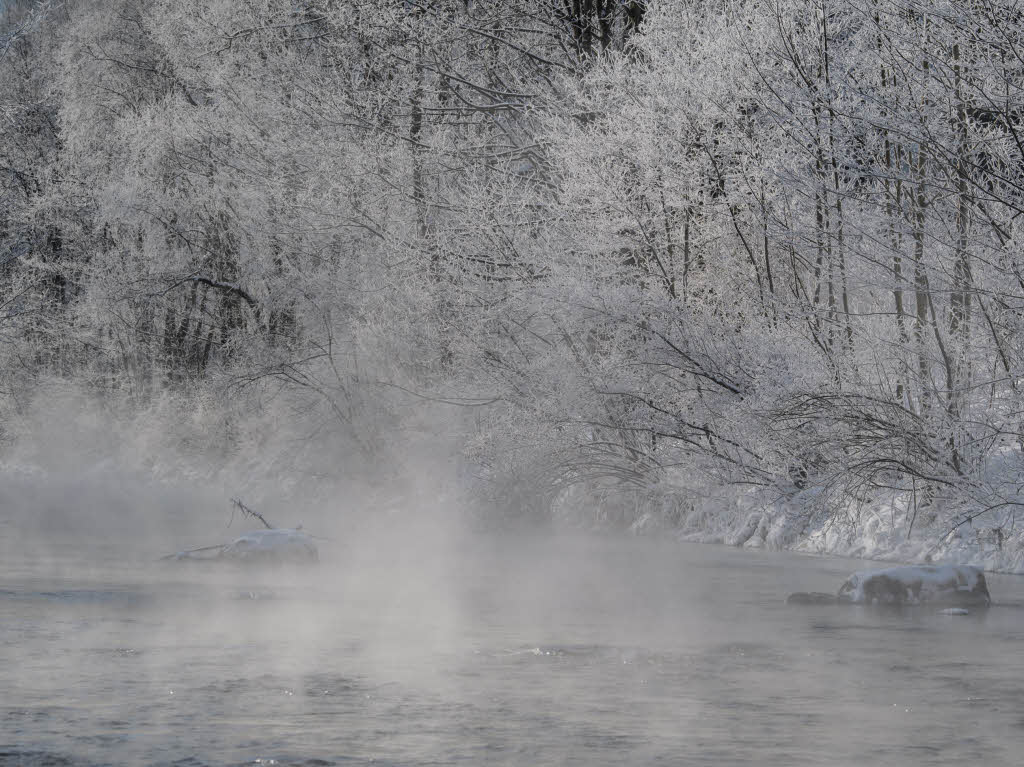 Bei minus 20 Grad Celsius steigt ber einem Bach bei Bayrischzell Dampf auf.