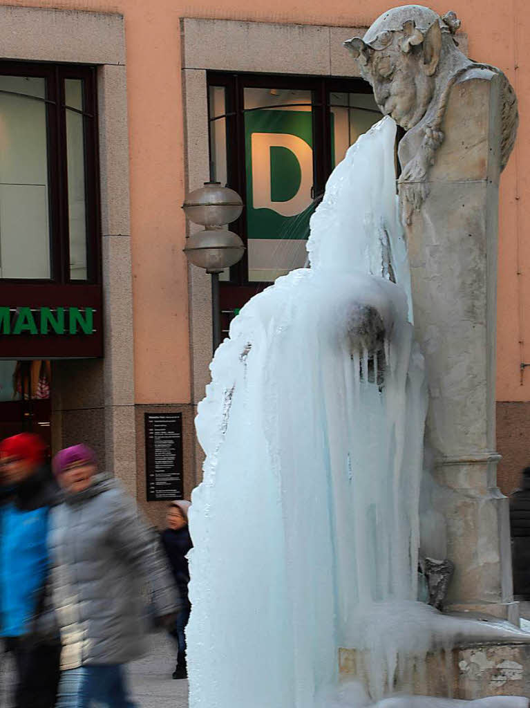Eine dicke Eisschicht bedeckt die Figur des „Brunnenbuberl in Mnchen