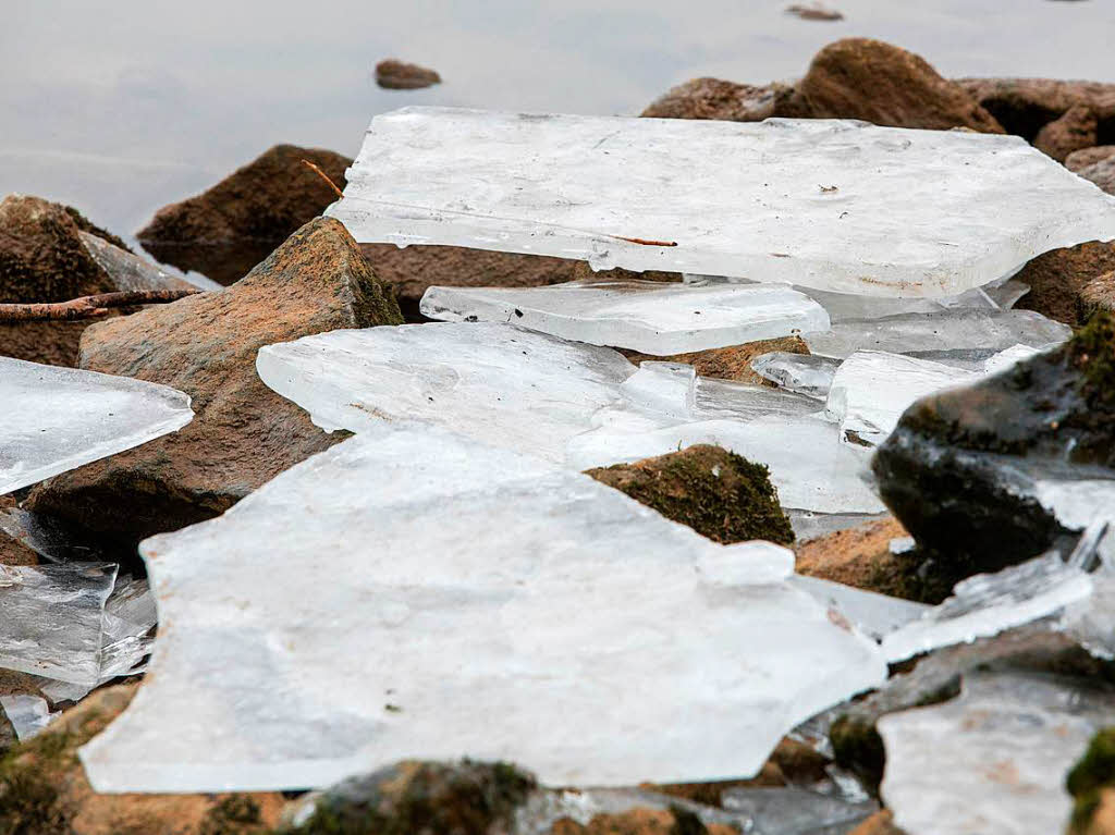 Eisschollen liegen auf den Steinen am Donauufer in Bayern.