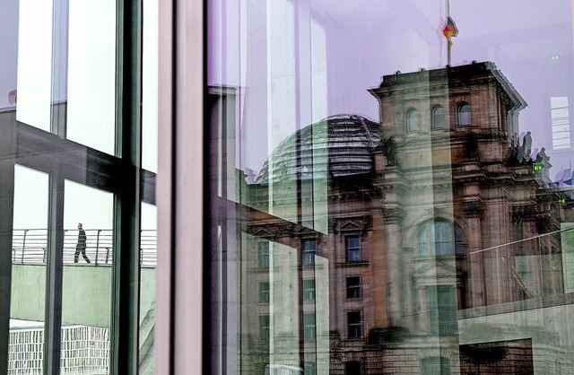 Verschwommenes Bild des Reichstags &#8...egelt sich im Glas einer Huserfront.   | Foto: dpa