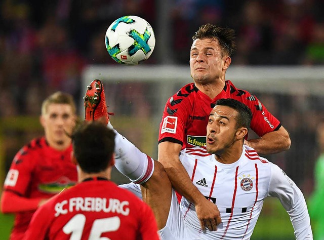 Augen zu und hoch das Bein: SC-Kicker Abrashi im Duell mit Bayern-Akteur Thiago   | Foto: Seeger (dpa)