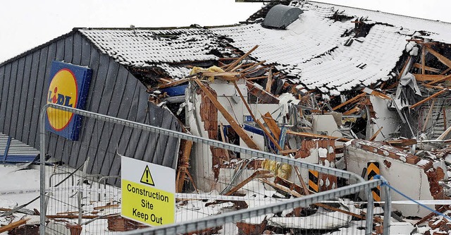 Das mit einer Baggerschaufel zerstrte Dach des Supermarktes.  | Foto: dpa