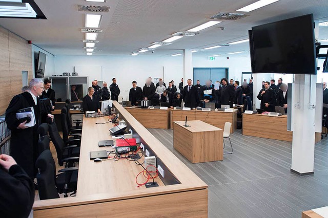 Die Angeklagten stehen in der Justizvo... zu Prozessbeginn im Verhandlungssaal.  | Foto: dpa