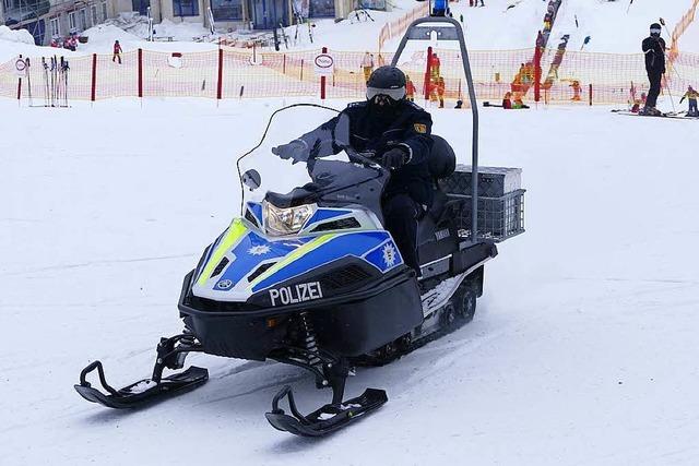 Polizisten sind am Feldberg mit dem Motorschlitten unterwegs