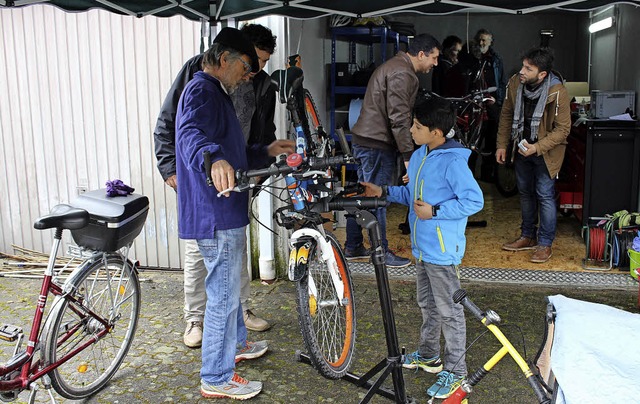 Die Initiatoren erklren den Geflchte...igkeiten am Fahrrad repariert werden.   | Foto: Axel Reibel