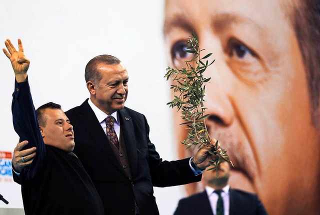 Der trkische Prsident Erdogan umarmt einen Untersttzer.  | Foto: DPA