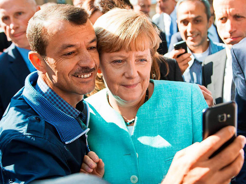 Doch ebenfalls 2015 wurde Angela Merkel zur Ikone der weltweiten Fluchtbewegung. Hier posiert sie im September 2015 nach dem Besuch einer Erstaufnahmeeinrichtung in Berlin zusammen mit einem Geflchteten fr ein Selfie.