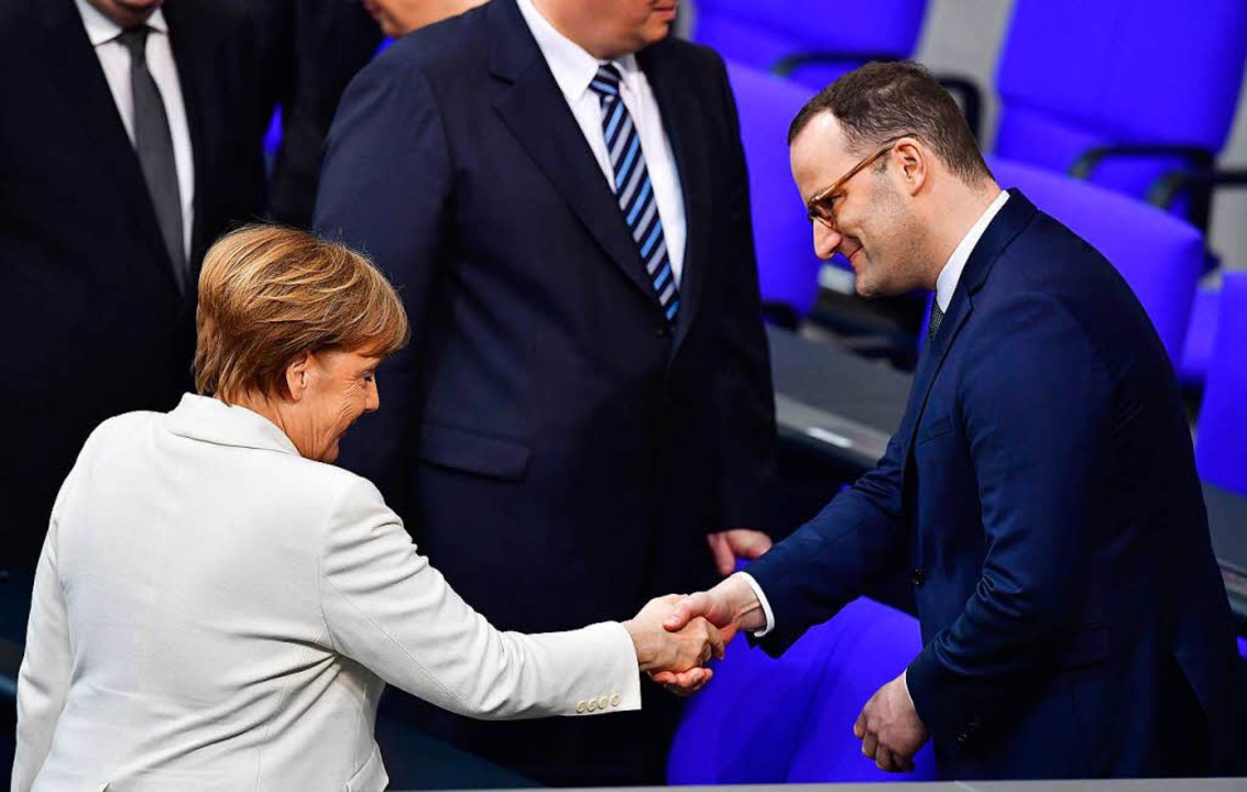 Händeschütteln: Kanzlerin Angela Merkel (l.) und Jens Spahn.  | Foto: AFP