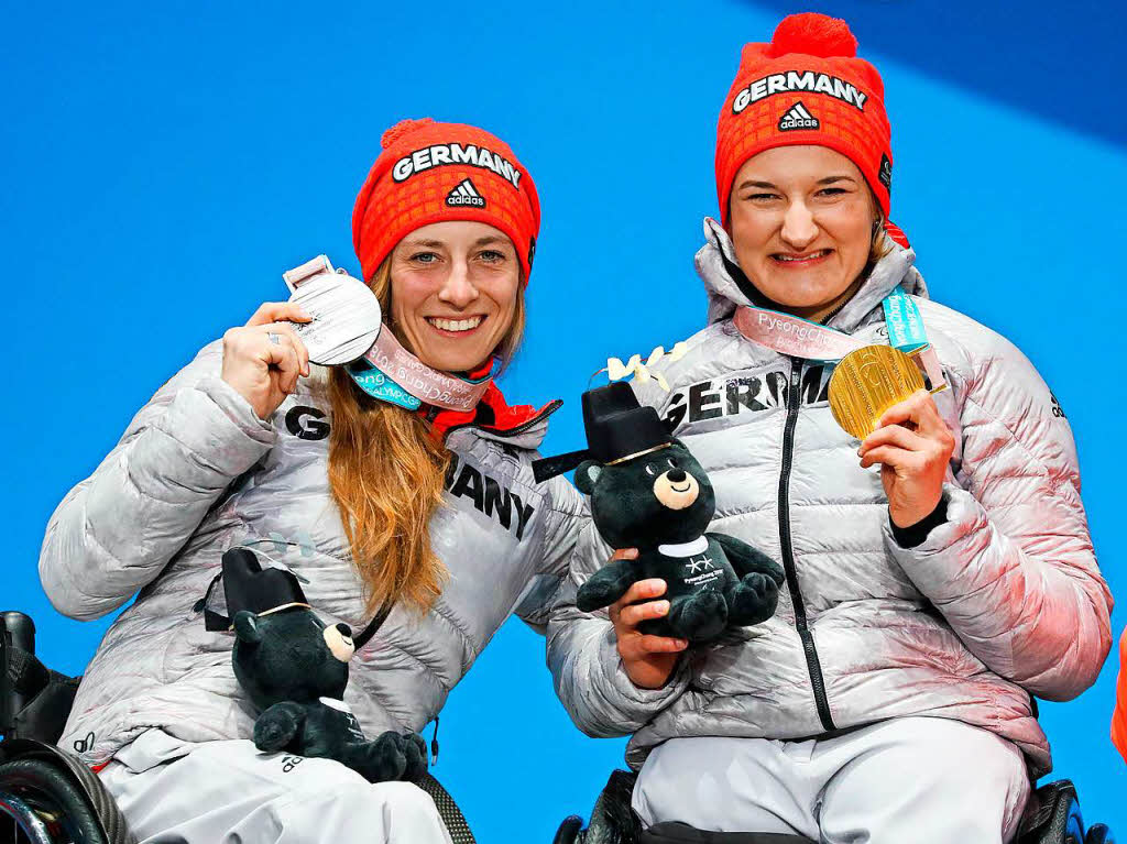Anna-Lena Forster (rechts, Gold) und Anna Schaffelhuber (Silber, beide Deutschland) freuen sich ber ihre Medaillen in der Super-Kombination (sitzend).