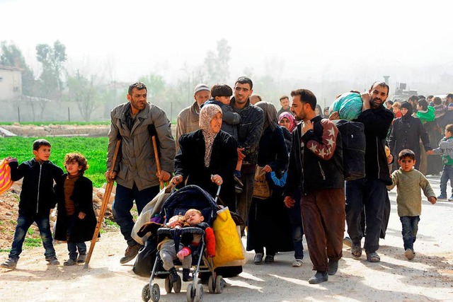 Menschen verlassen den Ort Hamuriyeh i...gerten Enklave Ost-Ghuta bei Damaskus.  | Foto: dpa