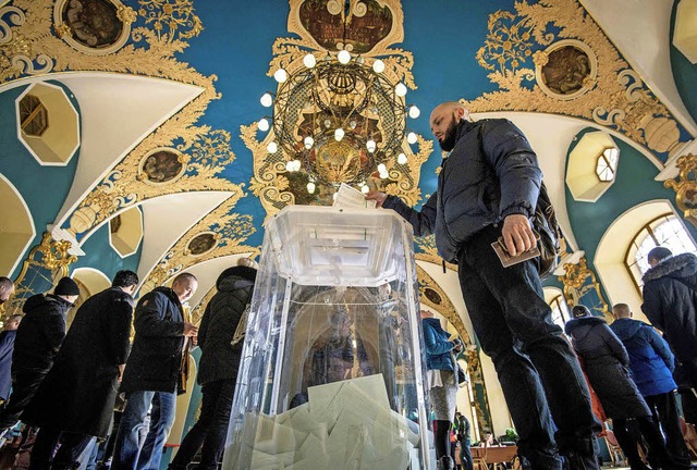 Whlerschlangen in einem Wahllokal im ...eschmckten  Kasaner Bahnhof in Moskau  | Foto: AFP