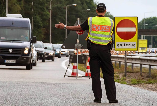 Ein Beamter der Bundespolizei leitet a...nden auf der A30 ber einen Parkplatz.  | Foto: dpa